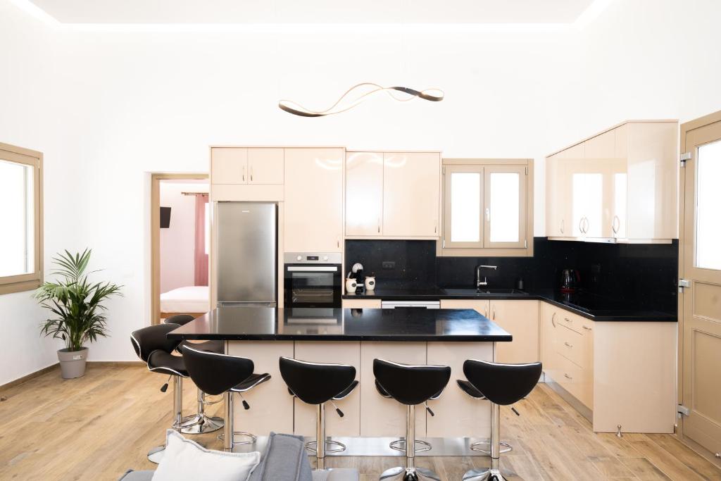 una cucina con ripiani neri e armadi bianchi di Maistros Apartments Mykonos a Ftelia