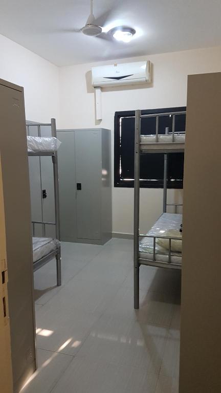 a room with two bunk beds and a ceiling fan at AJ Hostel in Dubai