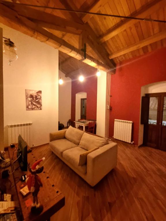ein Wohnzimmer mit einem Sofa und einem Tisch in der Unterkunft Civico16 Appartamento in LʼAquila