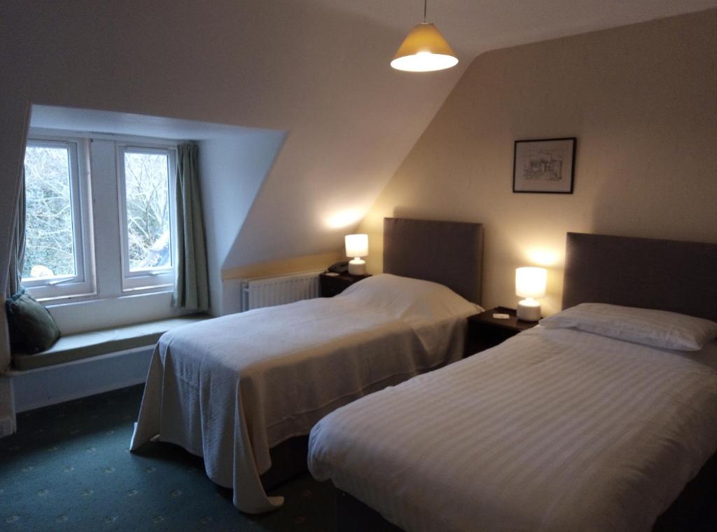 a hotel room with two beds and a window at Whitchester Christian Centre in Hawick