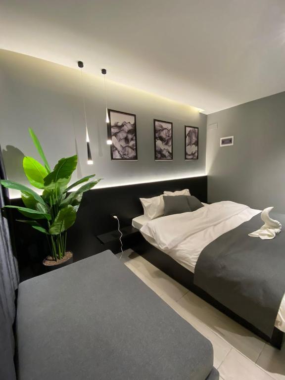 San Vito Luxury apartment في السويمة: غرفة نوم مع سرير وزرع الفخار