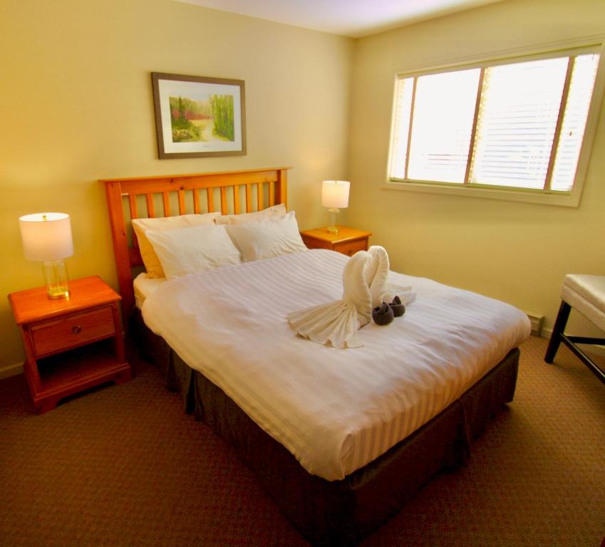 a bedroom with a bed with a bow on it at Timberline Condos - Aspen Building in Fernie