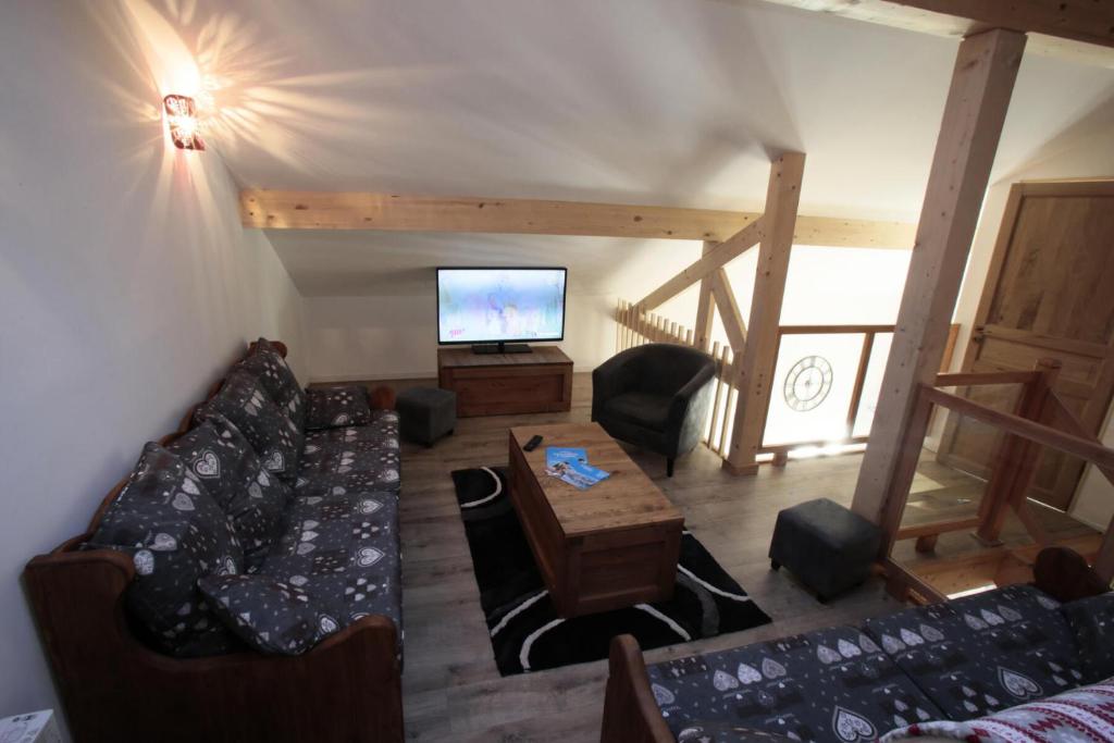 a living room with a couch and a tv at Les Chalets Du Grand Galibier - 4 Pièces pour 8 Personnes 94 in Valloire
