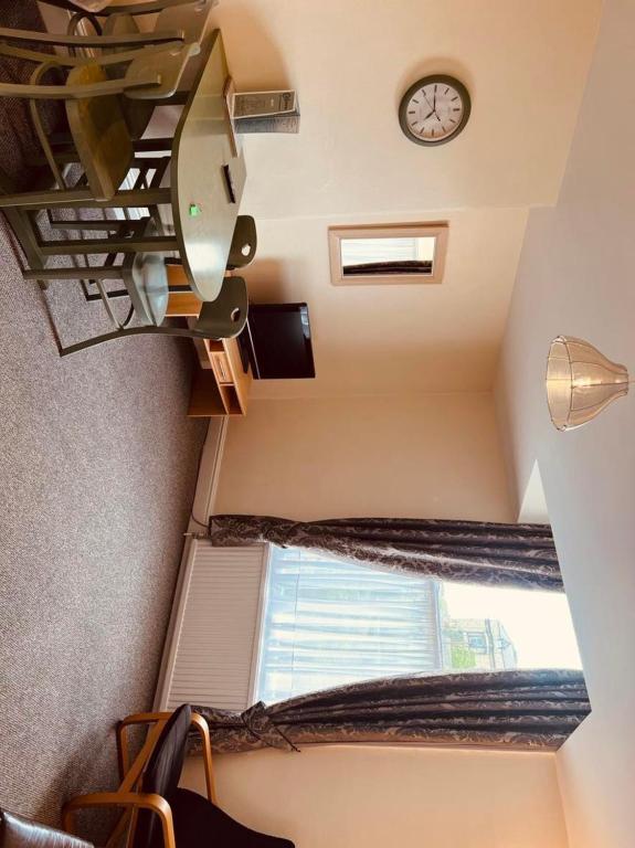 a staircase with a window and a clock on the wall at Brialene Holiday Flats in Scarborough