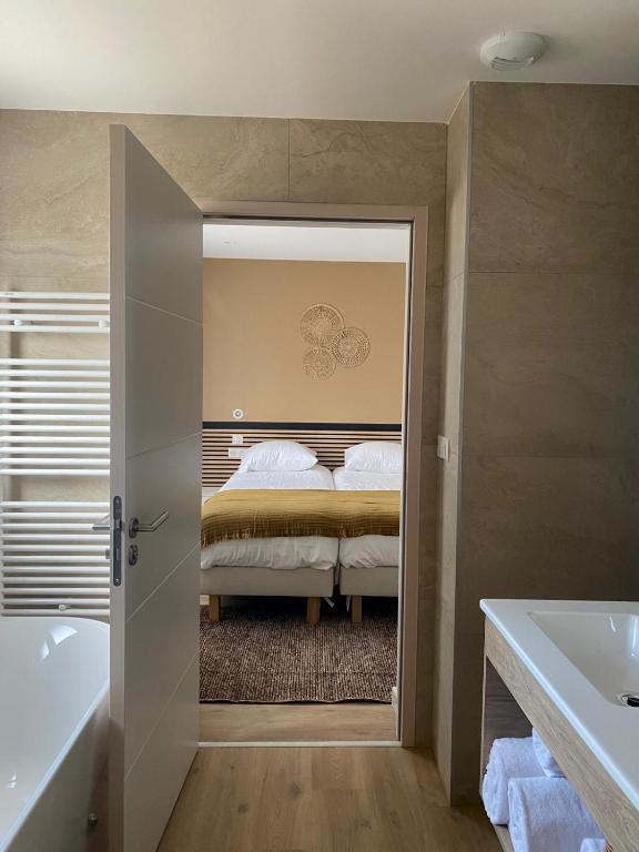 a bathroom with a bed and a tub and a bath tub at La Cremaillere Hôtel-Restaurant in Courseulles-sur-Mer