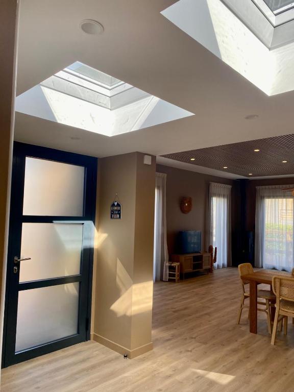 a living room with a ceiling with a skylight at La Cremaillere Hôtel-Restaurant in Courseulles-sur-Mer