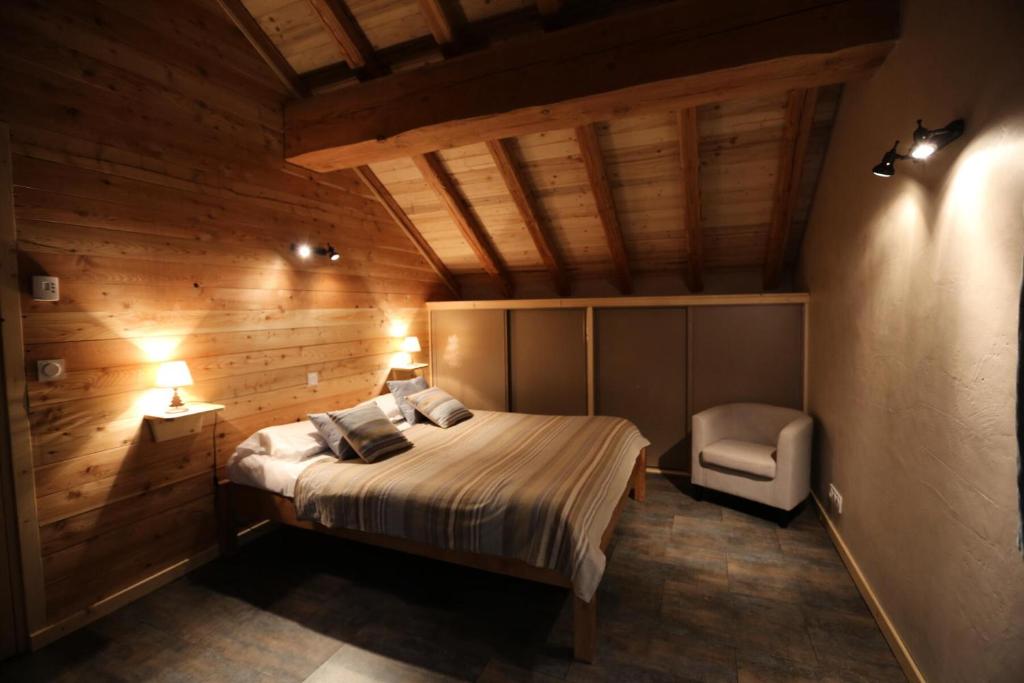 een slaapkamer met een bed en een stoel in een kamer bij Les Chalets D'adrien - 3 Pièces pour 6 Personnes 74 in Valloire