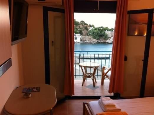 a room with a balcony with a view of the water at Lydia Mare in Agios Kirykos