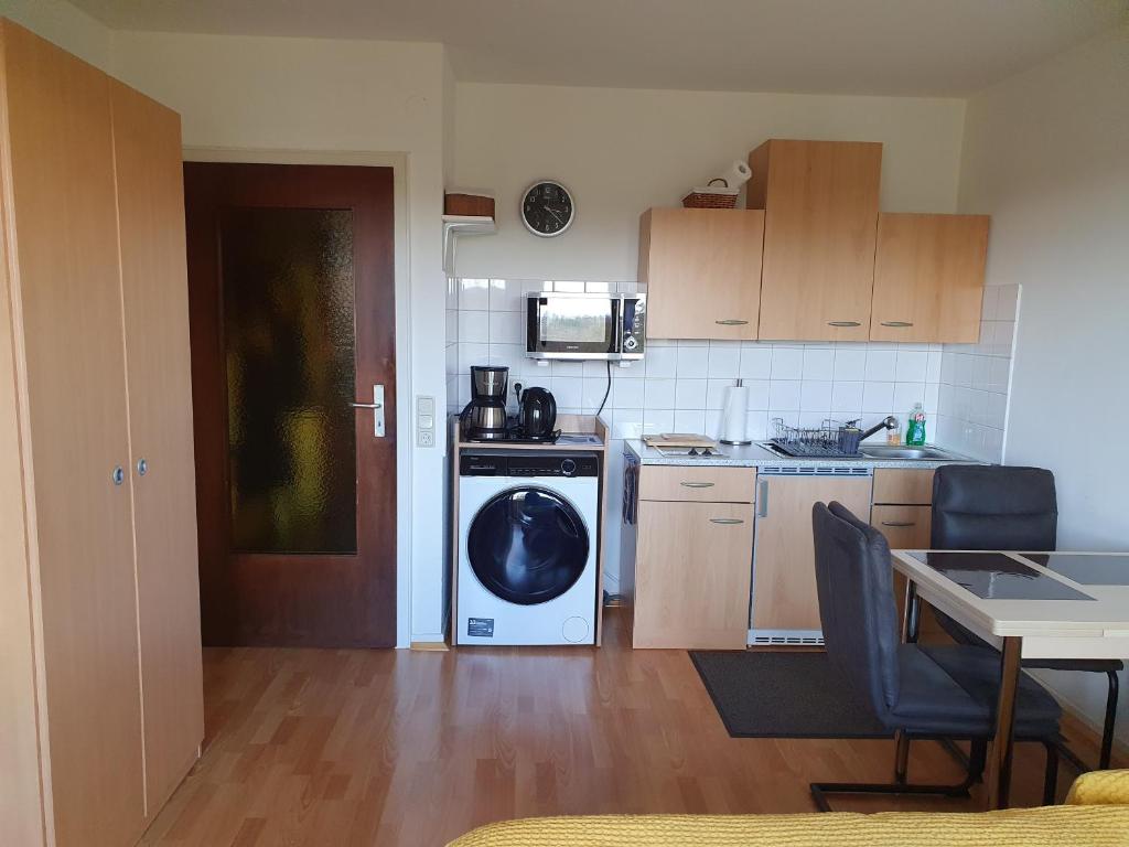 eine Küche mit einer Waschmaschine und einem Tisch in der Unterkunft Single-Apartment Essen in Essen