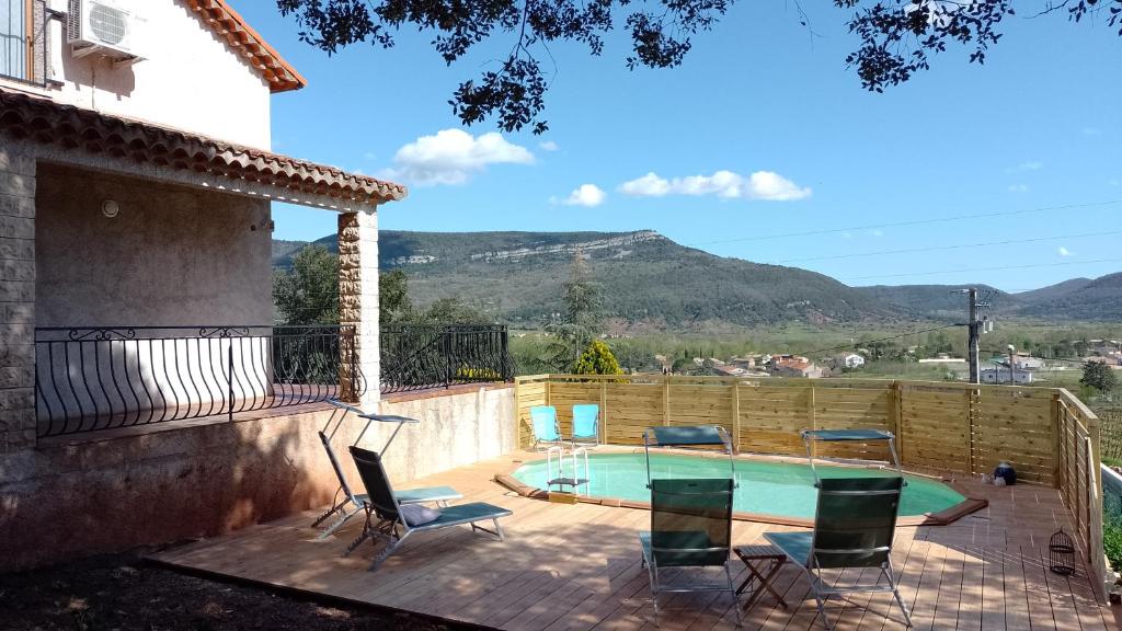 un patio avec des chaises et une piscine avec des montagnes en arrière-plan. dans l'établissement Lucinkas, à La Tour-sur-Orb