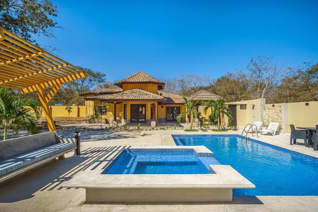 uma casa com piscina e uma casa em Casa Amarilla em Playa Avellana