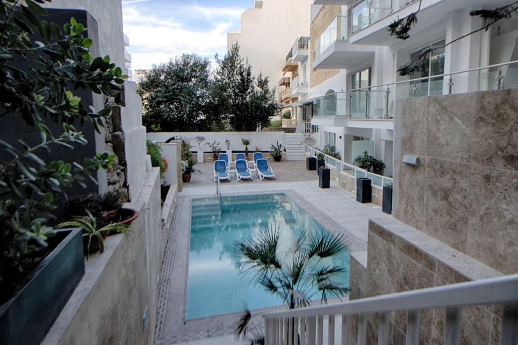 una piscina en medio de un edificio en 3bed Mellieha With Shared Pool, en Mellieħa