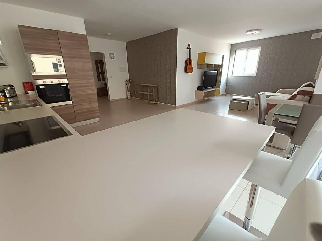 a kitchen and living room with a white table and chairs at Cosy 2bed Apartment In Manikata By Homely in Mellieħa
