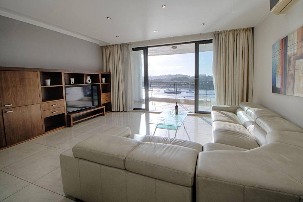 un soggiorno con divano e TV di The Strand Apartments By Homely a Sliema