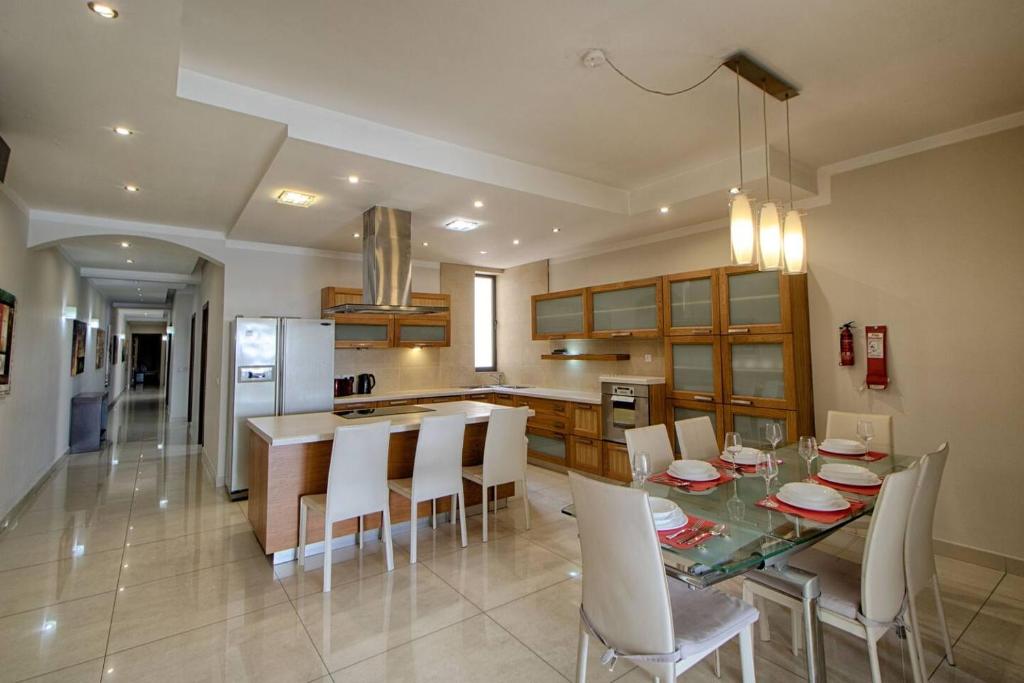 una cucina e una sala da pranzo con tavolo e sedie di The Strand Apartments By Homely a Sliema