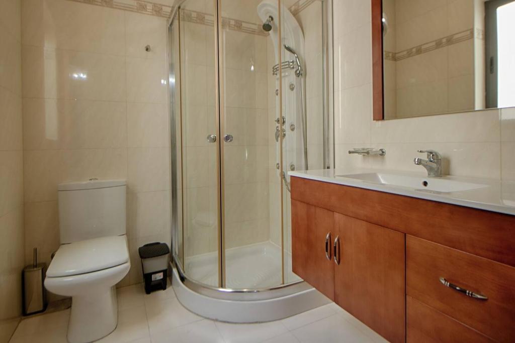un bagno con doccia, WC e lavandino di The Strand Apartments By Homely a Sliema