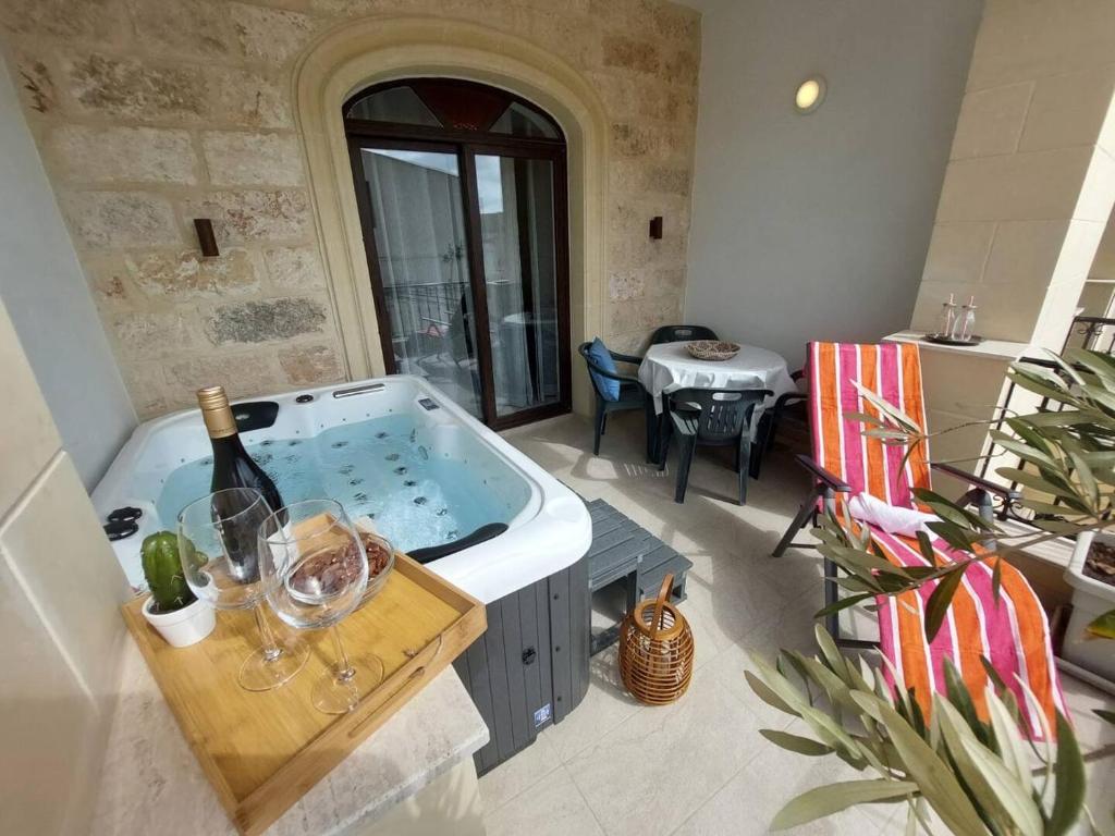 a large room with a tub with a bottle of wine at Ta'lonza2 Prime Location Reach Most Of The Island in Mellieħa
