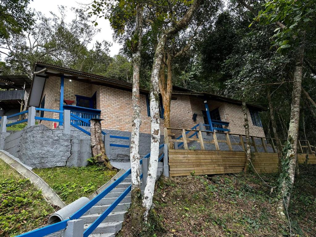 a house with a blue fence in front of it at Villa Cabanas - Pé na areia in Governador Celso Ramos