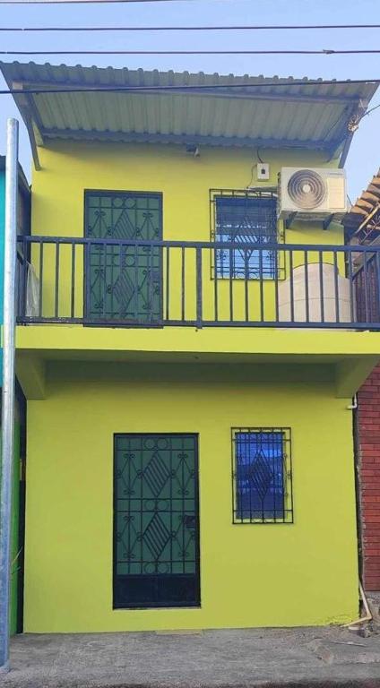 ein gelbes Gebäude mit Balkon darüber in der Unterkunft Casa El Majahual in Playa San Blas