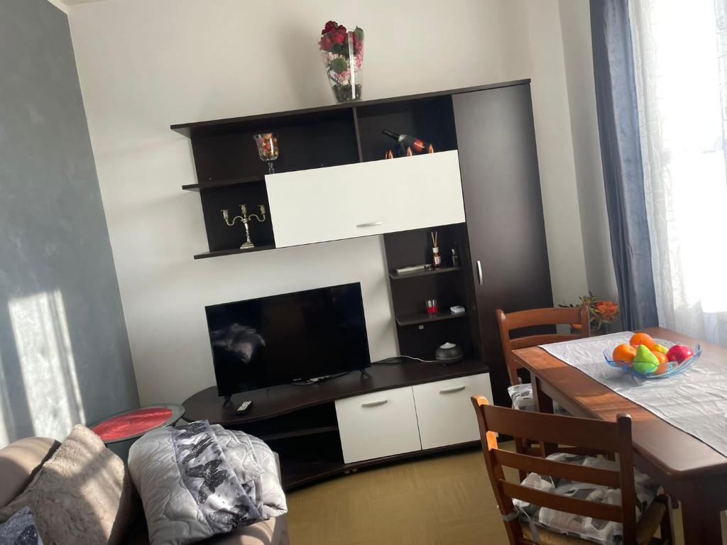 sala de estar con TV de pantalla plana y mesa en Appartamento ampio ed indipendente, en Formigliana