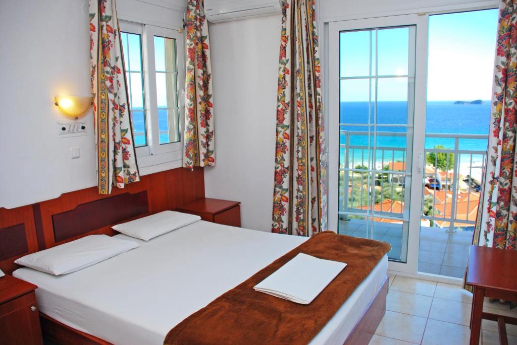 um quarto com uma cama e vista para o oceano em Hotel Smaragdi em Chrysi Ammoudia