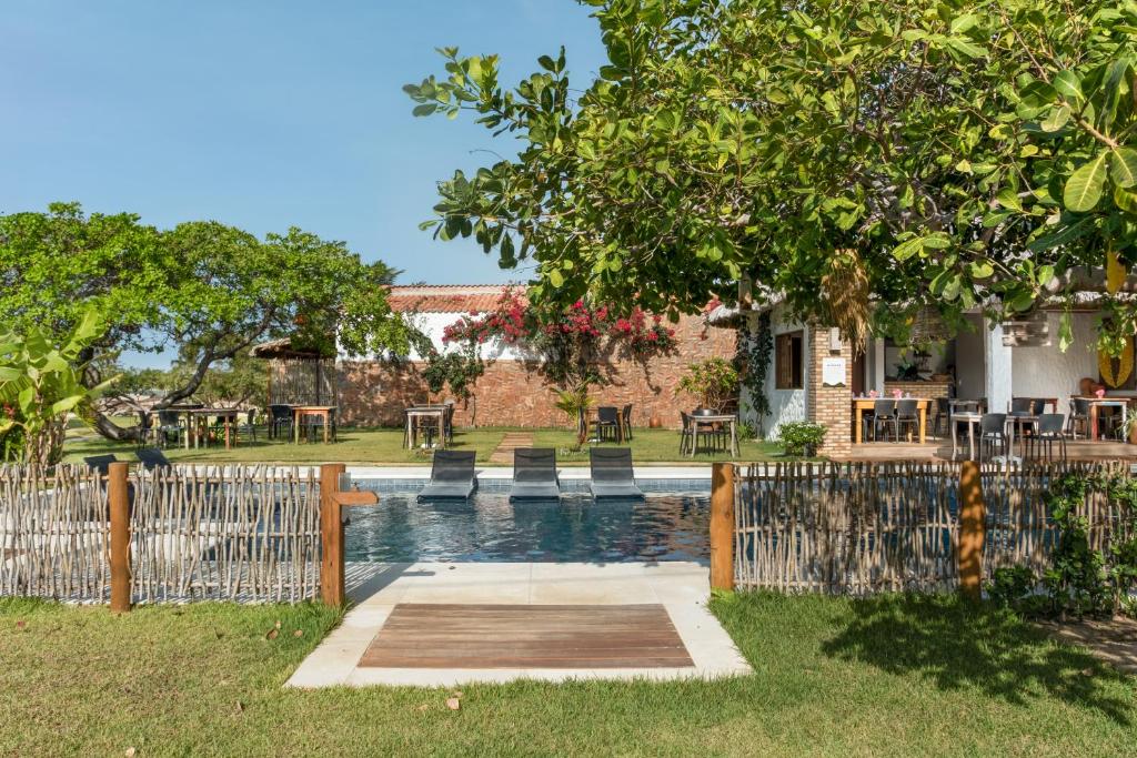 a fence with a pool in front of a house at Rancharia Charme Beach in Atins