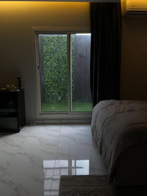 a bedroom with a bed and a large window at Eco-friendly studio close to all services in Riyadh