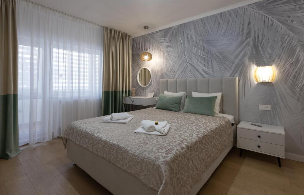 a bedroom with a bed with two towels on it at Imedio Olive Apartment Aviatiei in Bucharest