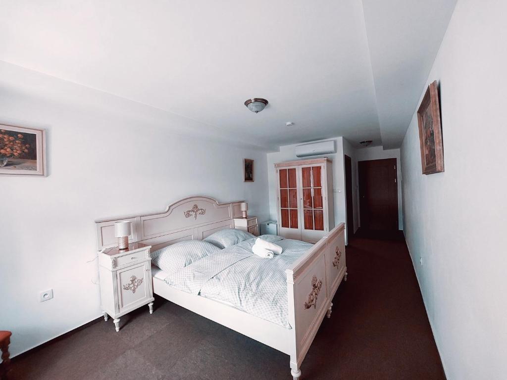 een witte slaapkamer met een bed en een dressoir bij Hotel u Jindry in Železnice
