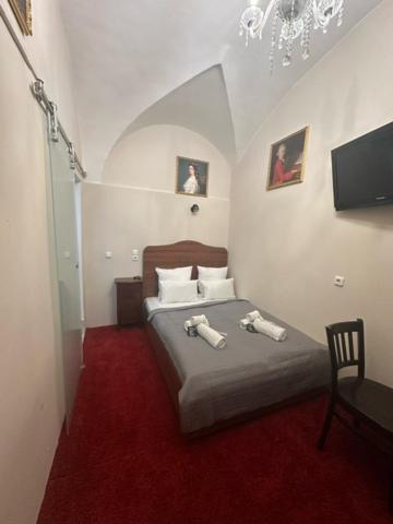 a bedroom with a bed with a red carpet at DATRI Petite Suite 8 in Vienna