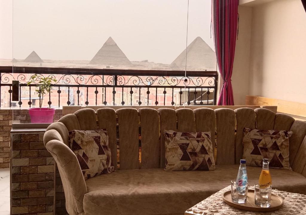 a couch in a room with two bottles on a table at Giza Pyramids View Apartment in Cairo