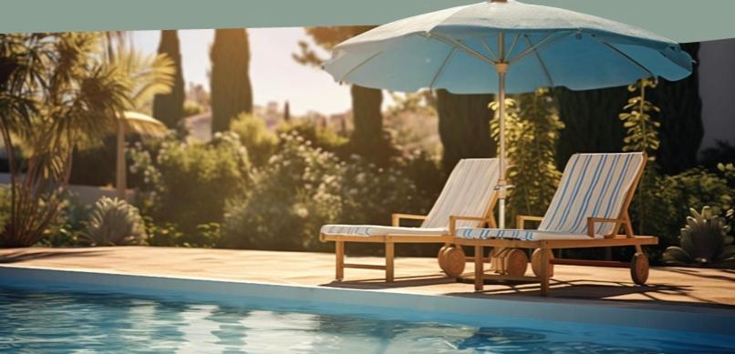 two chairs and an umbrella next to a swimming pool at JOHANNES LUXURY VILLAS in Kolymbia