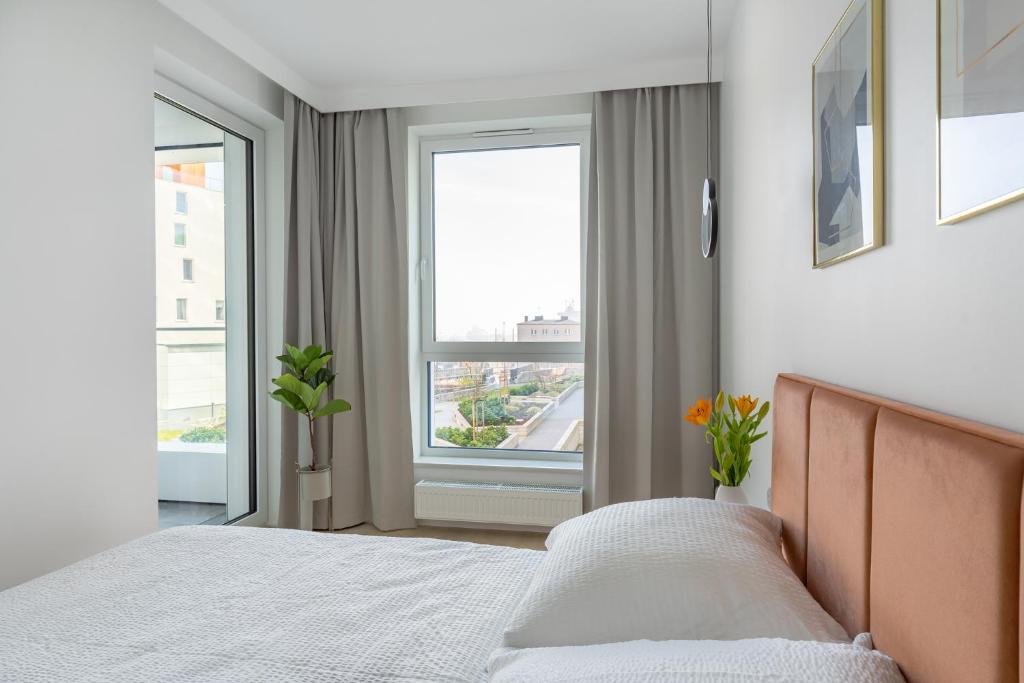a bedroom with a bed and two windows at Sea View Premium Apartment I PARKING - Widok na morze in Gdynia