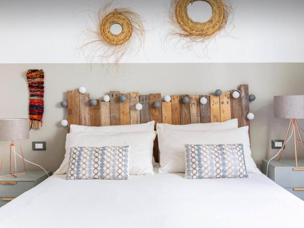 a bedroom with a white bed with two pillows at COCOON, Iconic Design in Historic Center & Breakfast in Sarzana