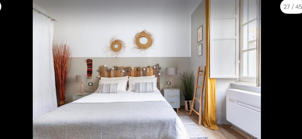 een slaapkamer met een bed en twee spiegels aan de muur bij Cocoon, Atypical flat in Historic center & Breakfast in Sarzana