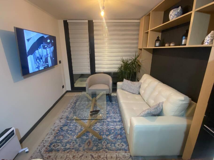 un soggiorno con divano bianco e sedia di Maravilloso Depto nuevo 2D 2B centro frente al lago a Puerto Varas
