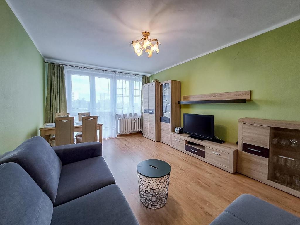 a living room with a couch and a tv at Legnicka Budget Stay - Grysko Apartament's in Szczecin