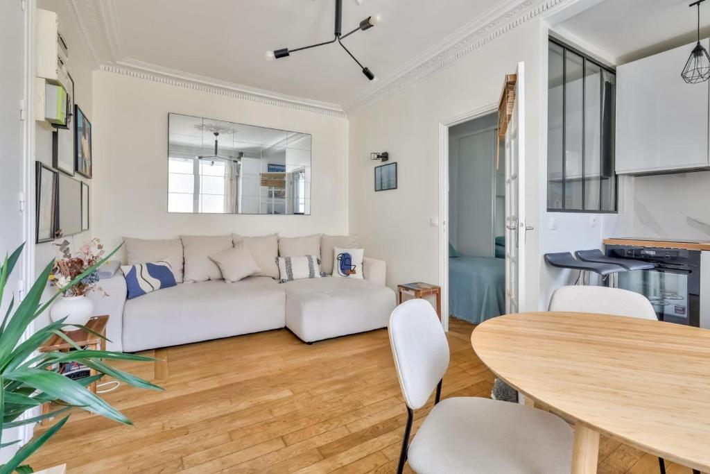 un salon avec un canapé blanc et une table dans l'établissement Apartment near Grands Boulevards, à Paris