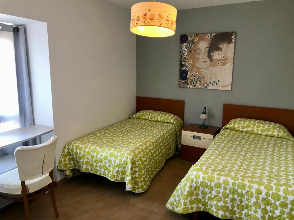 Una habitación de hotel con dos camas y una lámpara. en Casa do Horreo, en Puentecesures