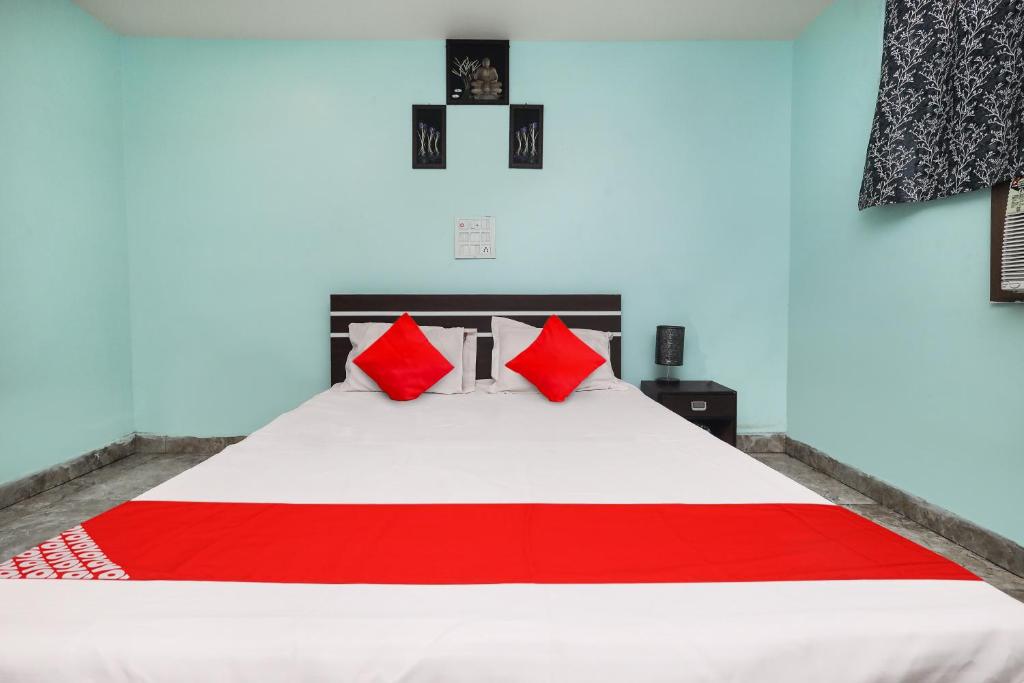 una camera da letto con un grande letto con cuscini rossi di Flagship 27A Hotel a Dhanbād