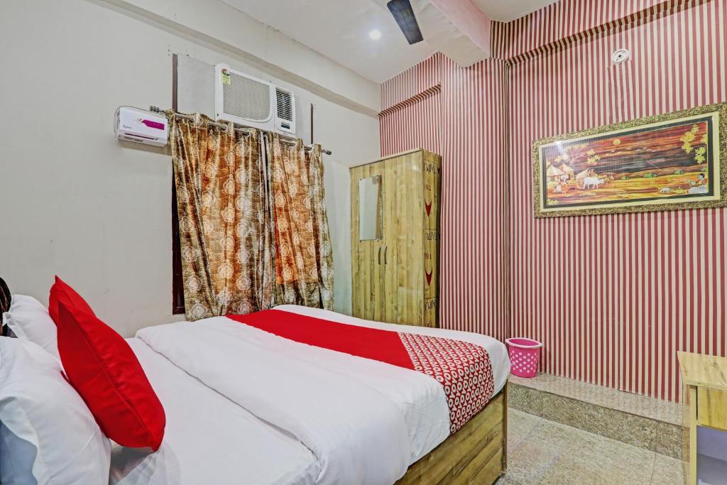 a bedroom with a bed with red and white stripes at OYO Flagship MH Palace in Lucknow