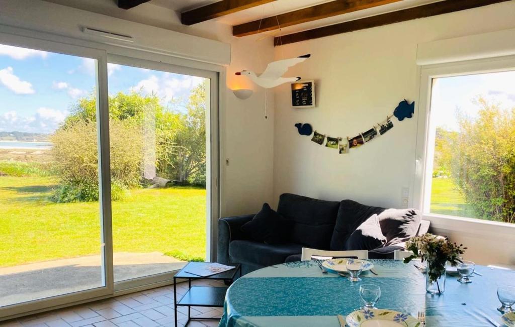 un salon avec un canapé et une grande fenêtre dans l'établissement Résidence D22-ile Grande - Maison de pêcheur dans un jardin sur la mer MAE-3464, à Pleumeur-Bodou