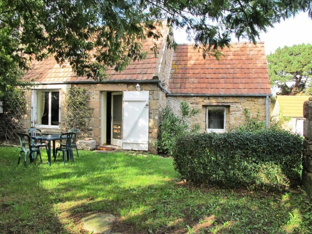 une petite maison en pierre avec une table dans la cour dans l'établissement Résidence P26-tregastel - Run Rouz maison classée 2 proche mer, Wifi, jardin et parking MAE-3484, à Trégastel