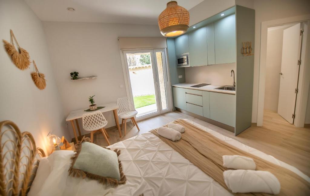 a bedroom with a bed and a kitchen with a table at La casa de las flores in Toro