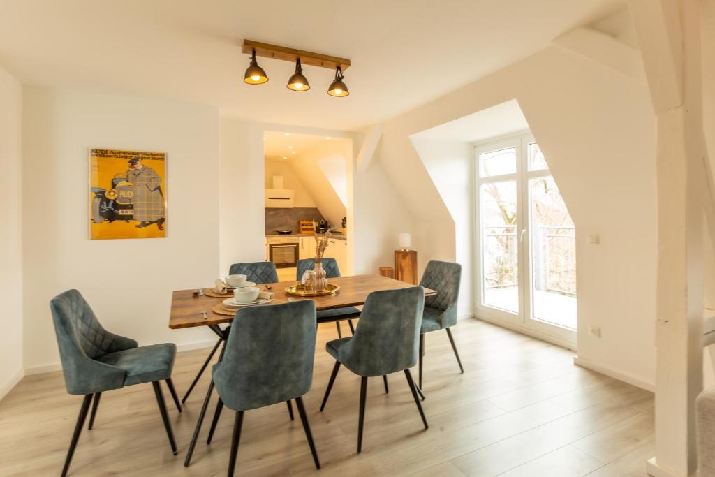 een eetkamer met een houten tafel en stoelen bij soulscape Apartments Zwickau kompakter LOFT-Wohnraum mit Lift direkt in die Wohnung, modern, zentrumsnah, gratis WIFI in Zwickau