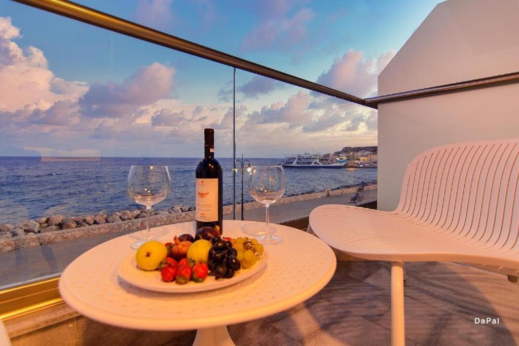 a bottle of wine and a plate of fruit on a table at Ocean Dreams in Palaiochóra