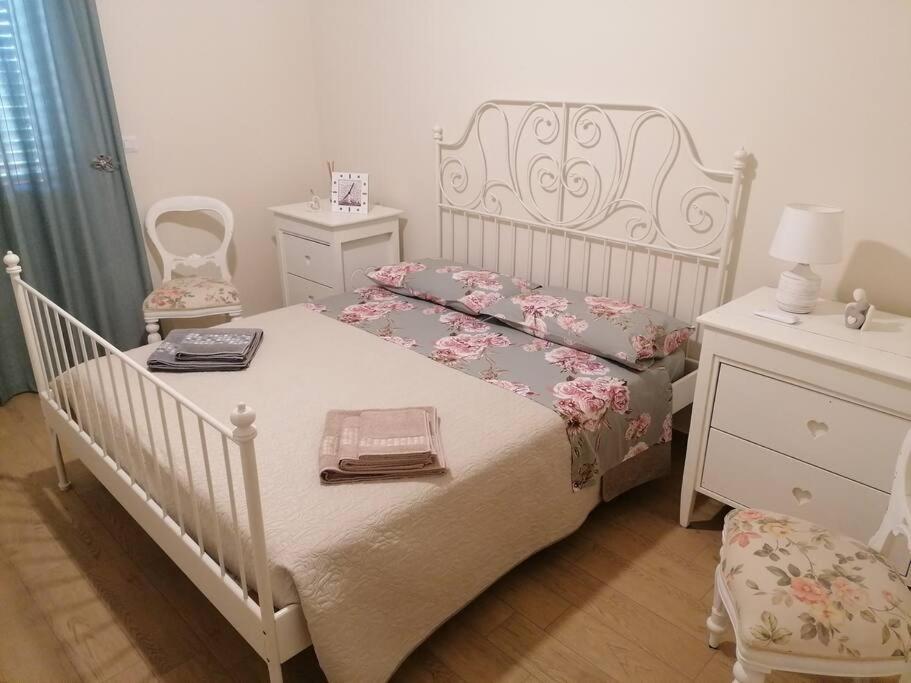 ein Schlafzimmer mit einem weißen Bett und einer Kommode in der Unterkunft B&b AmMarí. Appartamento - Bilocale. in Gallico
