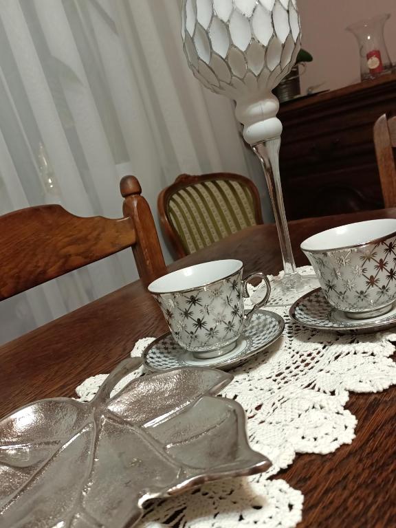 a wooden table with two cups and saucers on it at Mieszkanie Mickiewicza ... 45 in Sandomierz