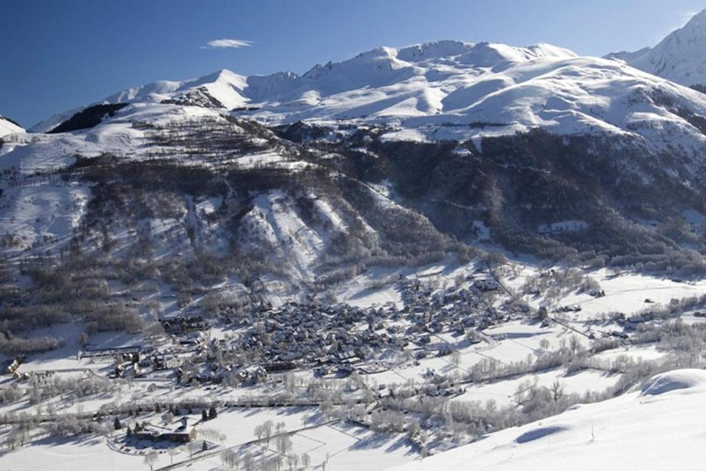Une montagne enneigée avec une petite ville dans la neige dans l'établissement Maison d'une chambre avec terrasse amenagee a Mont a 3 km des pistes, à Mont