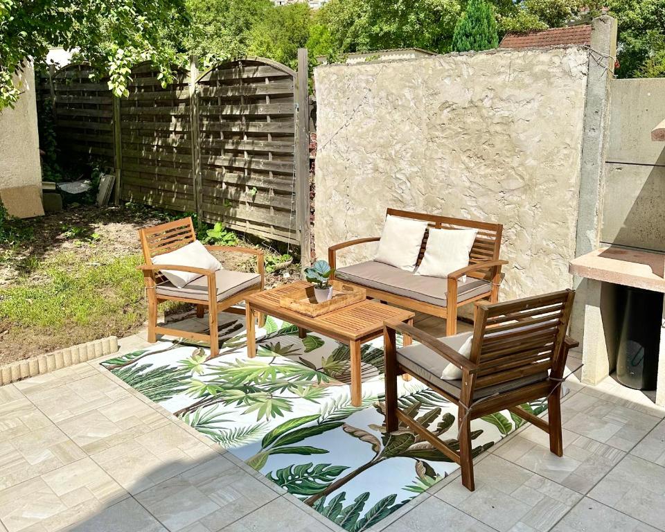 deux chaises et une table sur une terrasse dans l'établissement Charmante maison mitoyenne, à Melun